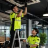 Dua Teknisi Memperbaiki AC di Gedung Jakarta